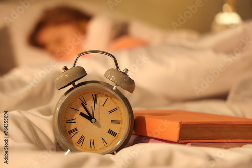 Alarm clock and books on be...