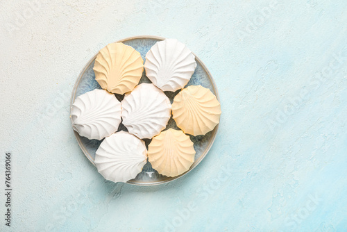 Plate of sweet zefirs on light blue background, top view photo