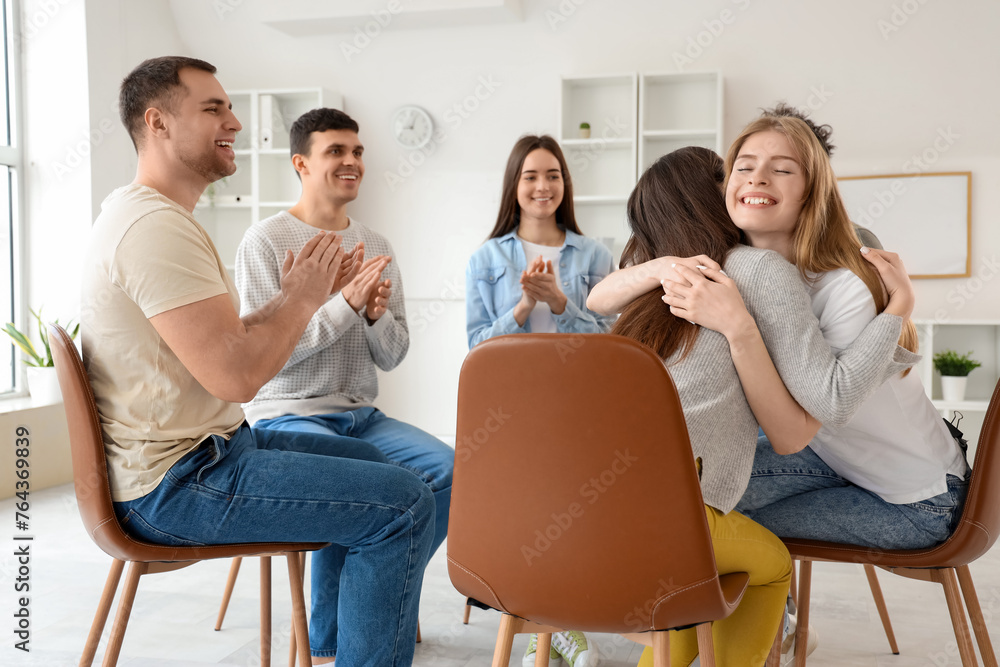 Young women hugging at group therapy session Young women hugging at group therapy session