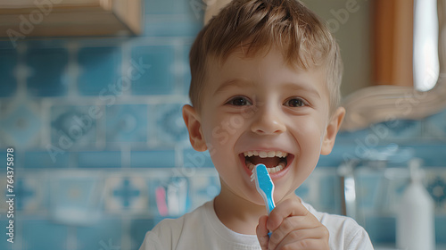 
A little boy washes his teeth in the morning to maintain dental or oral health, holds a toothbrush in his hands, smiles and looks at the camera