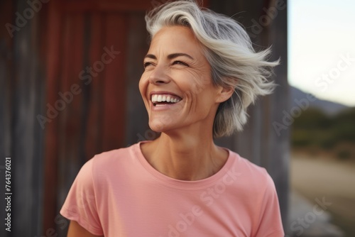 Close up portrait of a happy senior woman laughing and looking away while standing outdoors © Iigo