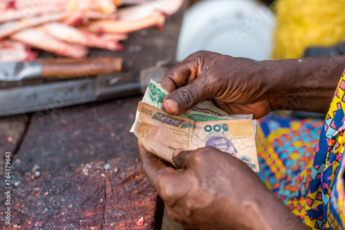 A man counts naira notes received as payment for meat at Bodija Market in Oyo, Nigeria on Monday, February 19, 2024.  photo
