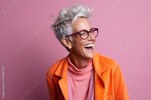Portrait of a happy senior woman in eyeglasses over pink background