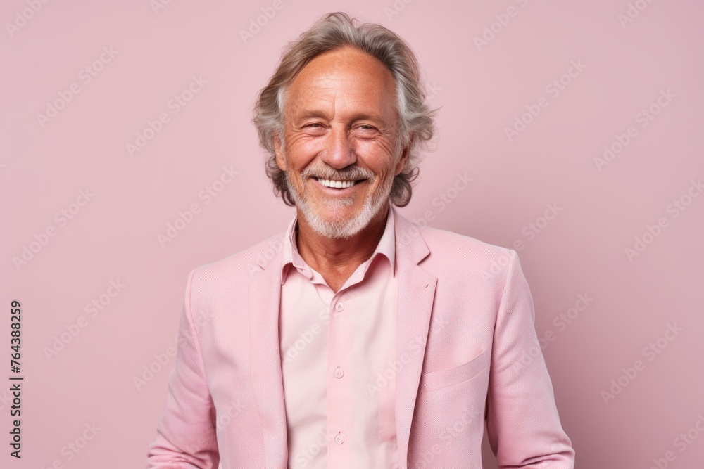 Portrait of a happy senior man in a pink suit standing against a pink background. Portrait of a happy senior man in a pink suit standing against a pink background.