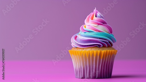 A vibrant cupcake with multicolored swirled icing on a purple background