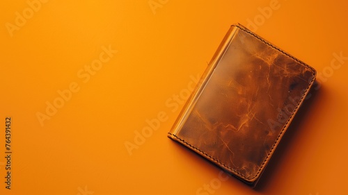 A wallet on a vibrant orange background with ample space photo