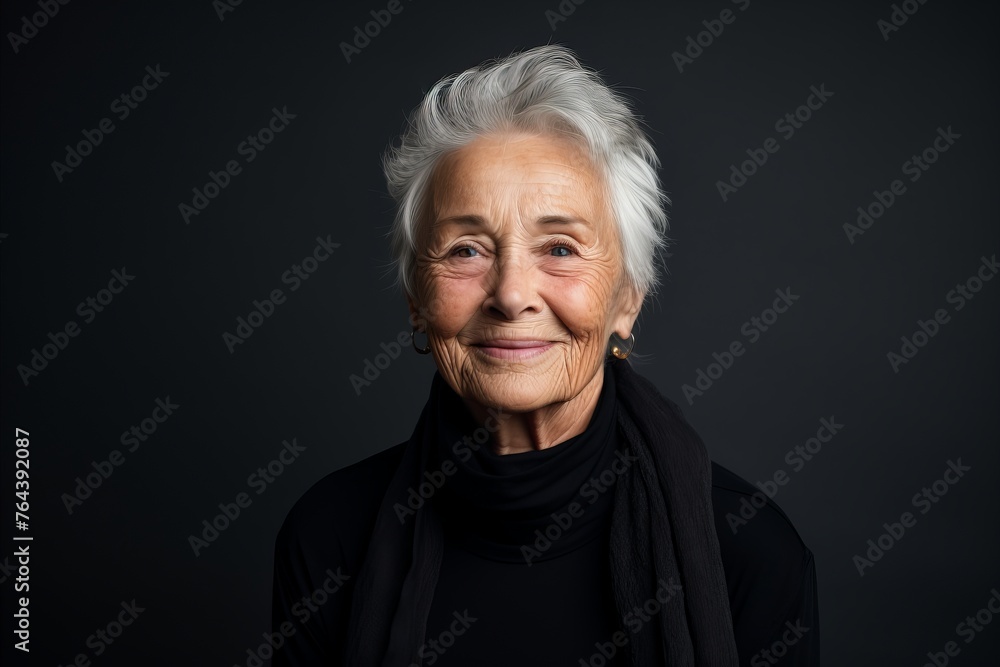Portrait of a smiling senior woman on a dark background. Studio shot. Portrait of a smiling senior woman on a dark background. Studio shot.