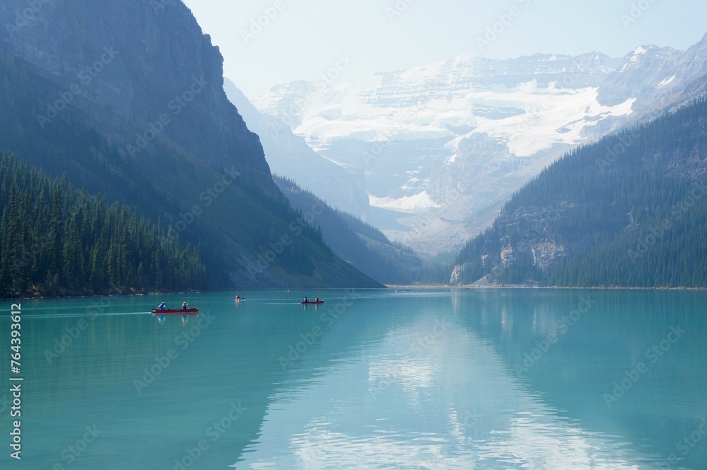 Brilliant turquoise waters of Lake Louise, Alberta with a backdrop  of majestic mountains and glaciers on a sunny autumn day