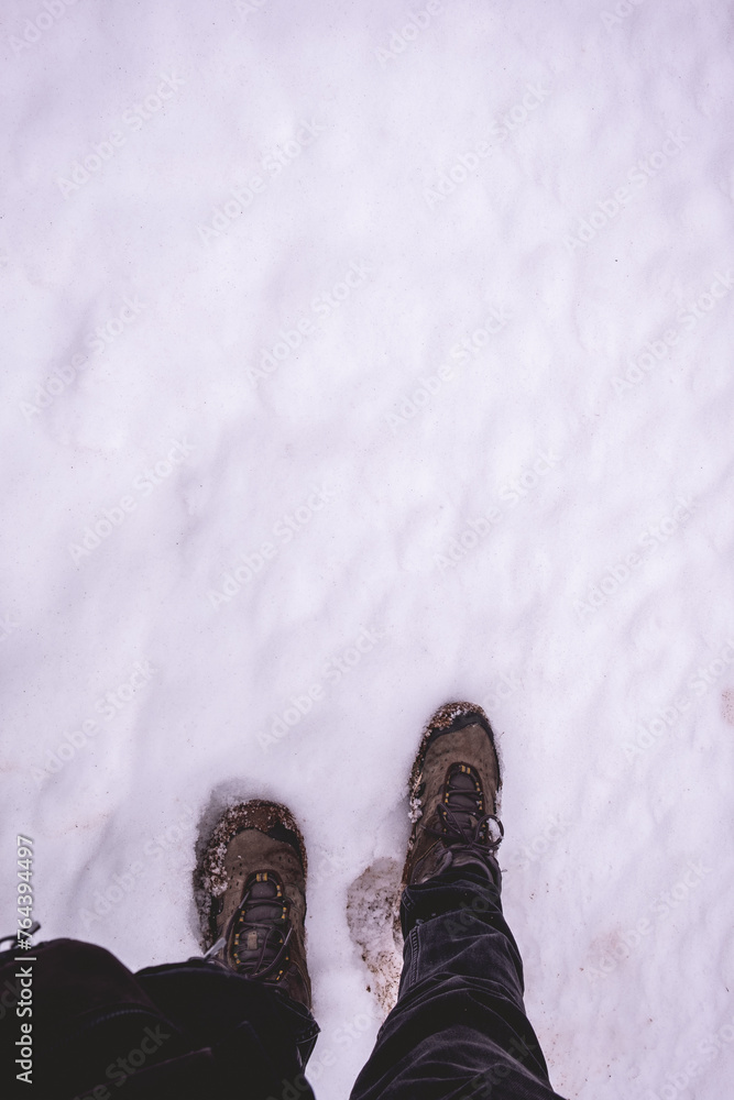 Winter's trek: a solitary journey through deep snow, first-person steps cutting through white and untouched snow Winter's trek: a solitary journey through deep snow, first-person steps cutting through white and untouched snow