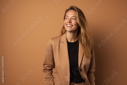 Happy young businesswoman in beige jacket on beige background.
