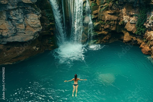 Girl swimming in a mountain lake by a waterfall © InfiniteStudio