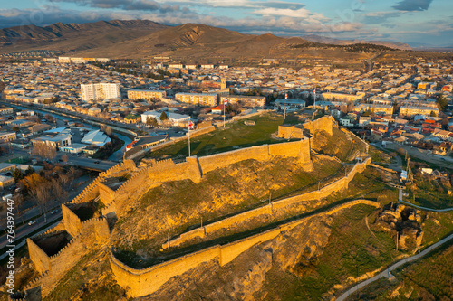 Scenic aerial view of medieval Gori Fortress on hilltop above Georgian city of Gori during spring sunset, Shida Kartli region photo