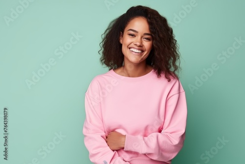 Portrait of smiling african american woman in pink sweater on blue background