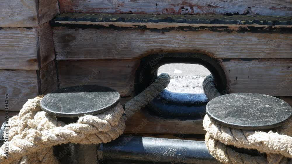 Close-up of rope tied around bollards on a ship's wooden deck, depicting secure maritime knotting. Ideal for themes of nautical expertise and vessel safety Close-up of rope tied around bollards on a ship's wooden deck, depicting secure maritime knotting. Ideal for themes of nautical expertise and vessel safety
