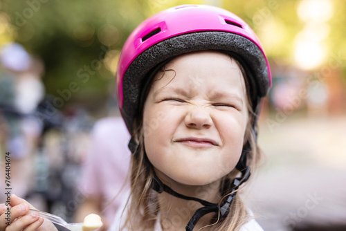 Cute young girl in helmet making funny face