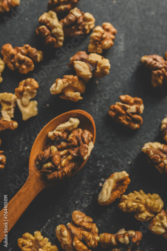 Walnuts in a wooden spoon on a black background