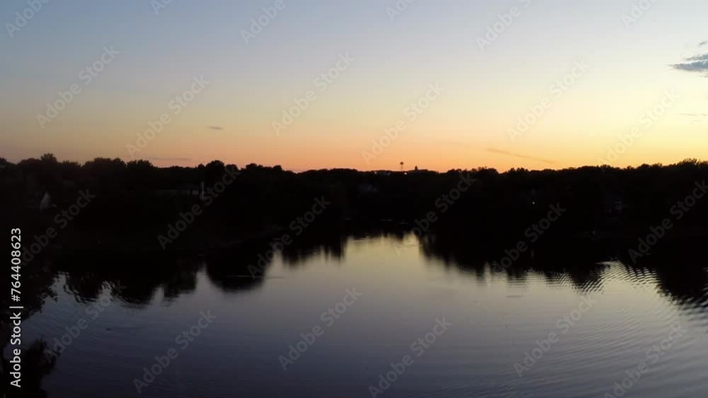 Aerial Forward Shot Of Nautical Vessel Moving On Rippled River Against Orange Clear Sky During Sunset - Buckner, California Aerial Forward Shot Of Nautical Vessel Moving On Rippled River Against Orange Clear Sky During Sunset - Buckner, California