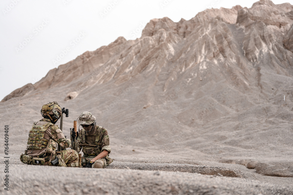 Soldiers in camo gear during a tactical operation with binoculars and rifles on a rocky terrain, showcasing military precision and readiness. Soldiers in camo gear during a tactical operation with binoculars and rifles on a rocky terrain, showcasing military precision and readiness.