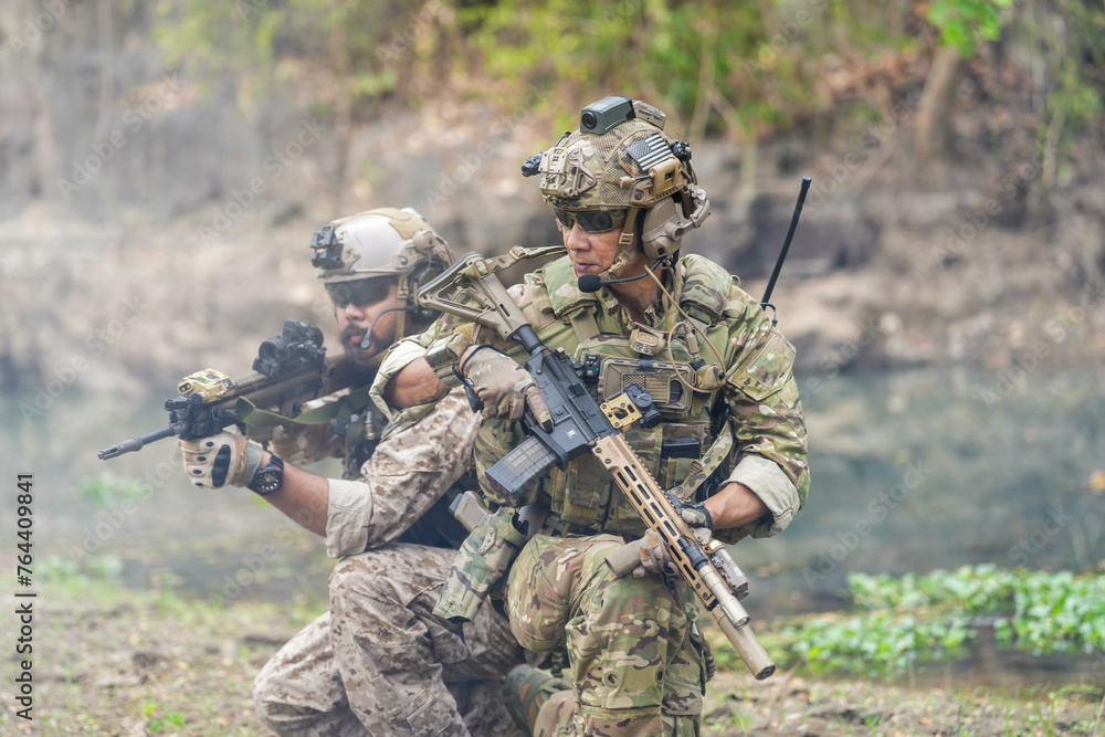 Soldiers in tactical gear aiming guns during a military exercise, showcasing teamwork and defense strategies.