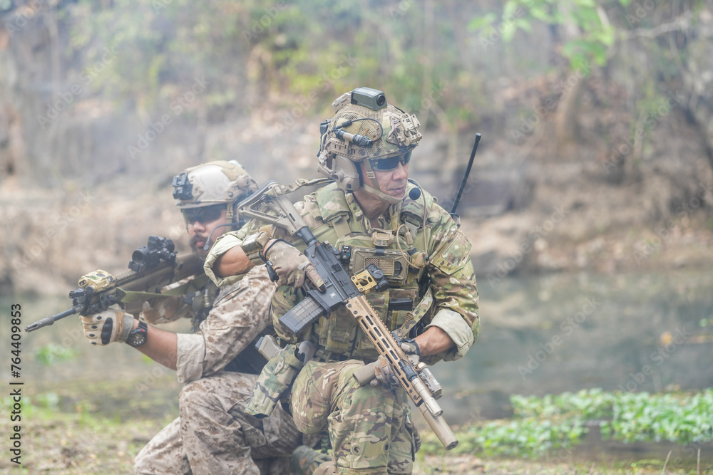 Soldiers in tactical gear aiming guns during a military exercise, showcasing teamwork and defense strategies.