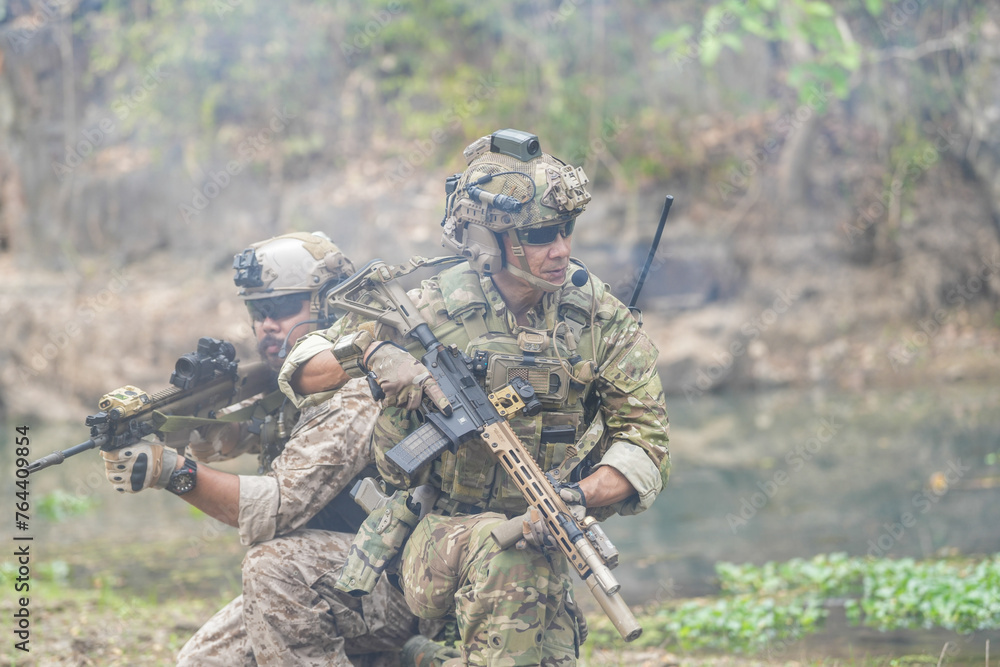 Soldiers in tactical gear aiming guns during a military exercise, showcasing teamwork and defense strategies. Soldiers in tactical gear aiming guns during a military exercise, showcasing teamwork and defense strategies.