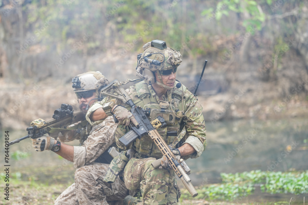 Soldiers in tactical gear aiming guns during a military exercise, showcasing teamwork and defense strategies.