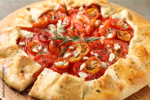 Tasty galette with tomato, rosemary and cheese (Caprese galette) as background, closeup