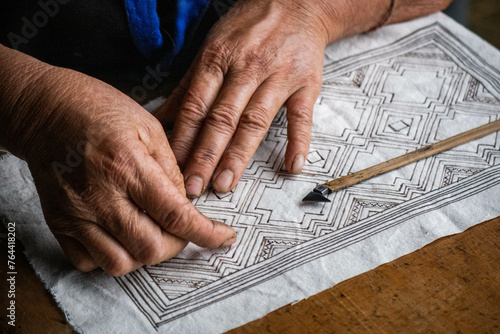 A Flower Hmong woman draws a pattern for her traditional embroidery, Mu Cang Chai, Yen Bai, Vietnam