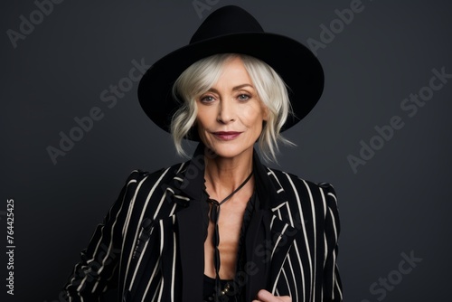 Portrait of stylish senior woman in black hat and striped jacket.