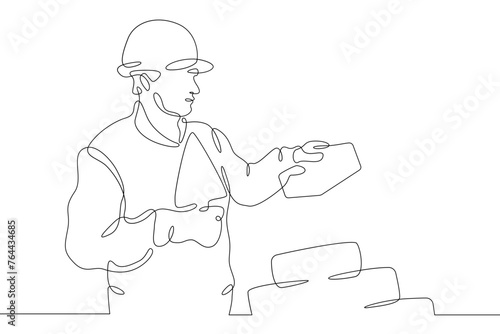 One continuous line.Bricklayer at a construction site. Home construction.Builder with a tool in his hands.Laying the wall. Construction worker.One continuous line is drawn on a white background.