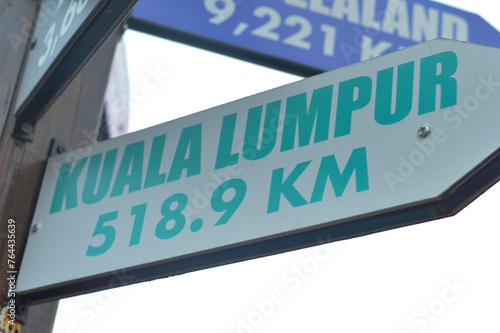 Close-up shots of directional signs pointing towards the enchanting destinations of the Kuala Lumpur photo