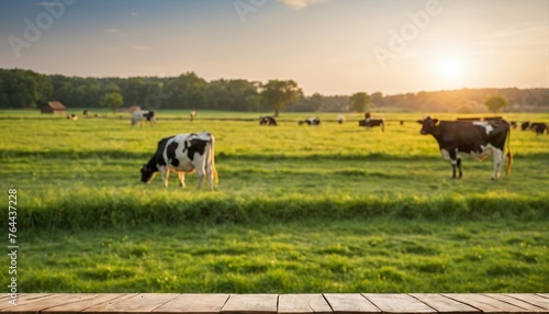 Summer morning light over a grassy field with cows and farm, viewed from an empty wooden table top, perfect for showcasing products