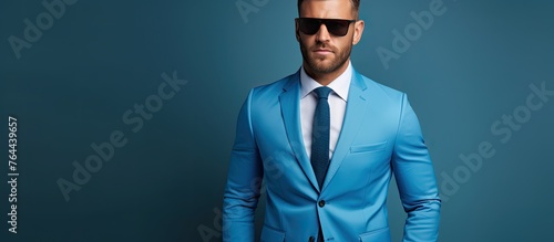 A man in a smart navy suit and trendy sunglasses looking fashionable and confident photo