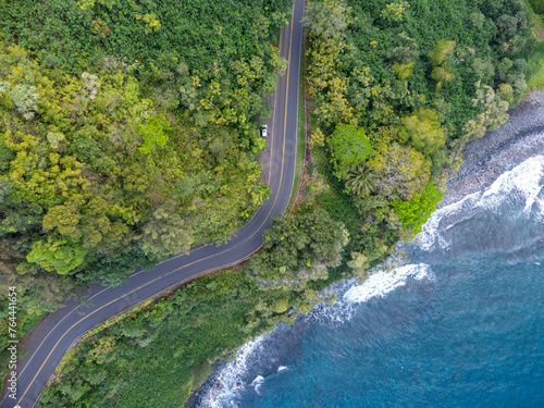 An aerial view of a winding road along a lush tropical coastline with crystal clear turquoise water. Road to Hana, Maui Hawaii.  photo