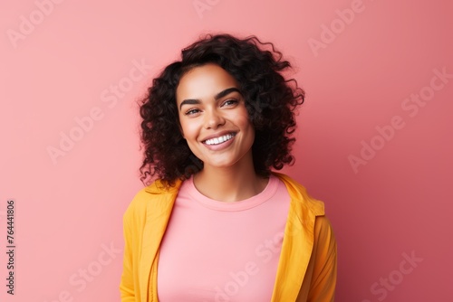 Happy young african american woman looking at camera over pink background