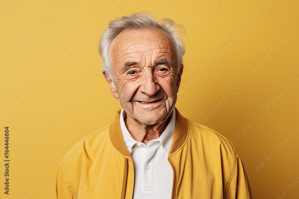 Portrait of smiling senior man looking at camera isolated over yellow background Portrait of smiling senior man looking at camera isolated over yellow background