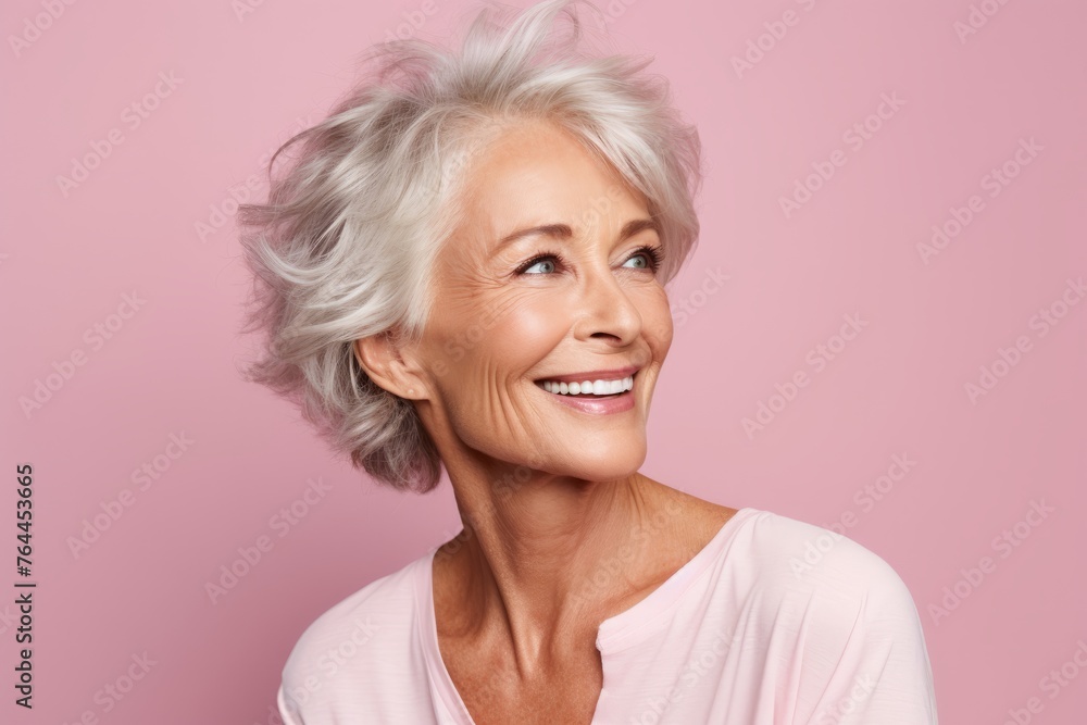Portrait of a smiling senior woman looking at the camera over pink background Portrait of a smiling senior woman looking at the camera over pink background