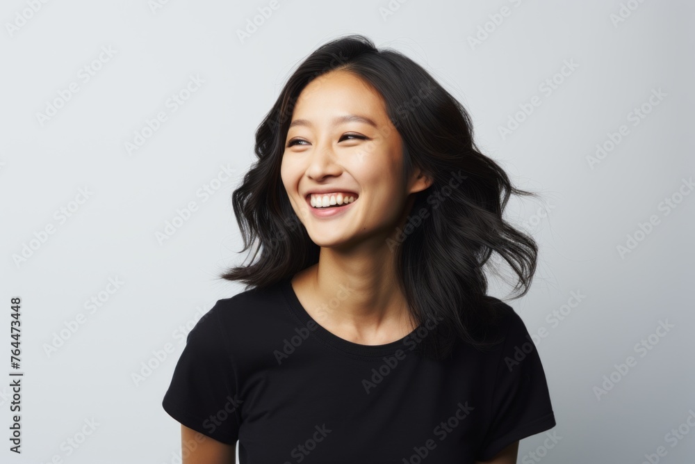 Portrait of a happy young asian woman laughing, over grey background Portrait of a happy young asian woman laughing, over grey background