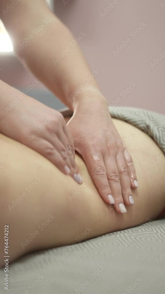 Caucasian woman undergoing manual oil massage of her back. Vertical video. Caucasian woman undergoing manual oil massage of her back. Vertical video.