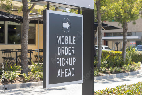 Mobile Order Pickup Ahead directional signage outside a fast food restaurant.