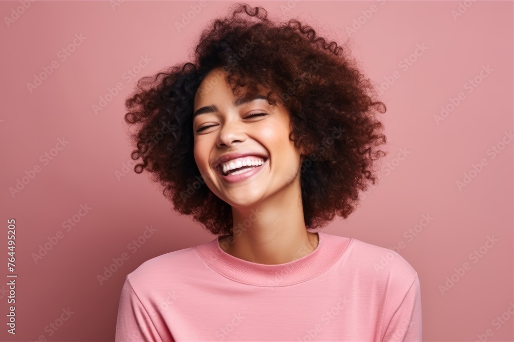 Portrait of a beautiful young african american woman laughing against pink background Portrait of a beautiful young african american woman laughing against pink background
