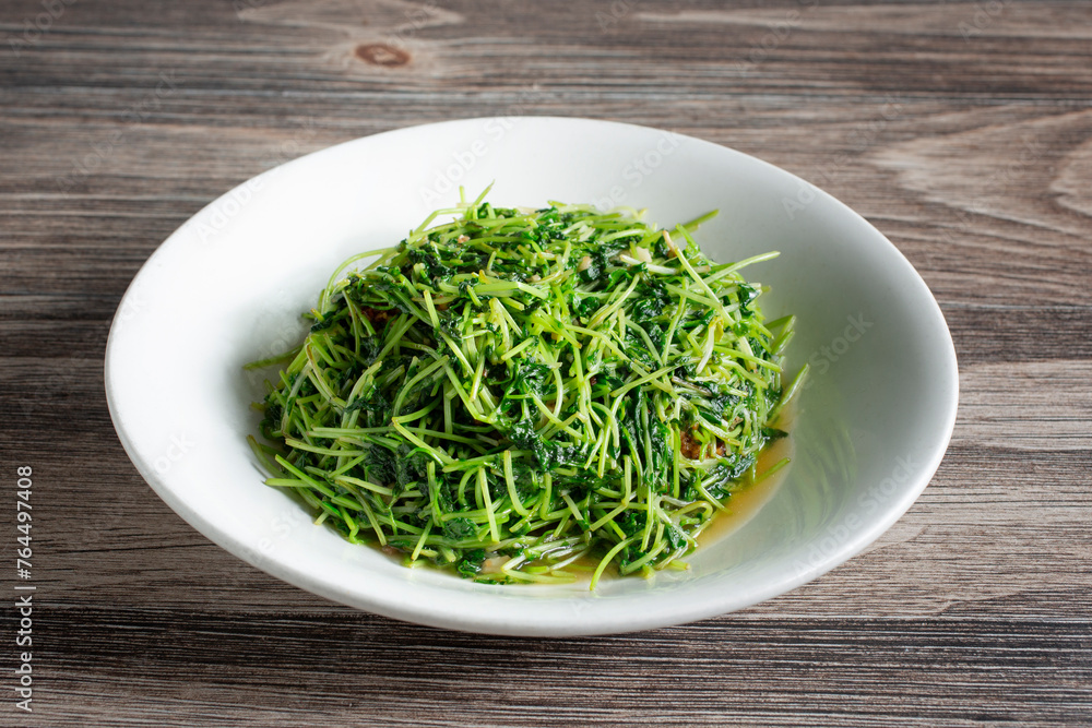 A view of a plate of sauteed pea sprouts. A view of a plate of sauteed pea sprouts.