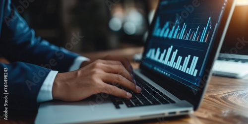 Man is typing on laptop with graph on screen