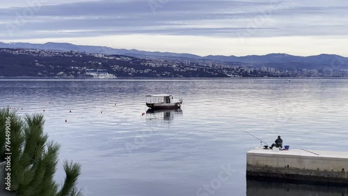 Wallpaper Mural Fisherman on peer Boat parked on Sea shore with town in distance close up, Opatija, Croatia Torontodigital.ca
