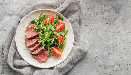 Beef salad. top view of fresh salad with beef steak slices, arugula and tomatoes on white plate. healthy salad, copy space