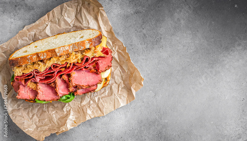 Reuben Sandwich. top view shot of Reuben Sandwich with Classic American pastrami and corned beef, and lettuce on brown paper. copy space