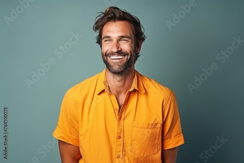 Portrait of a handsome man smiling at the camera over blue background