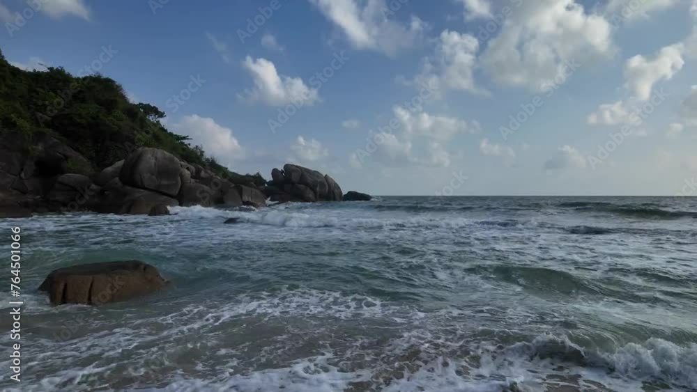 Waves crash against the rocky shores of Koh Samui. Evening sea with horizon of white clouds. Thailand Waves crash against the rocky shores of Koh Samui. Evening sea with horizon of white clouds. Thailand