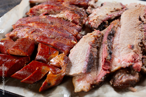 A closeup view of assorted smoked meats on a tray.