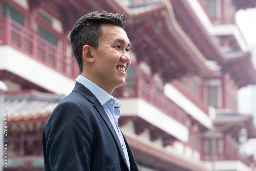 Fototapeta premium Chinese businessman in front of blurred Chinese heritage building.